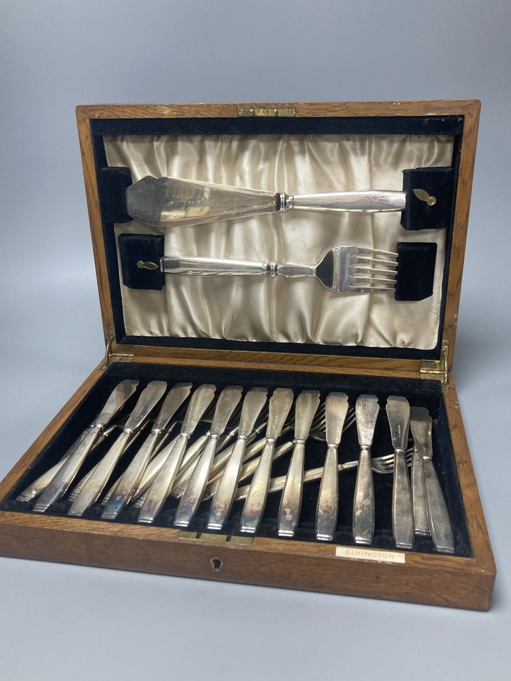A cased Elkington plated canteen of Rochester-pattern cutlery, near complete, and similar oak cased set of twelve fish knives and forks